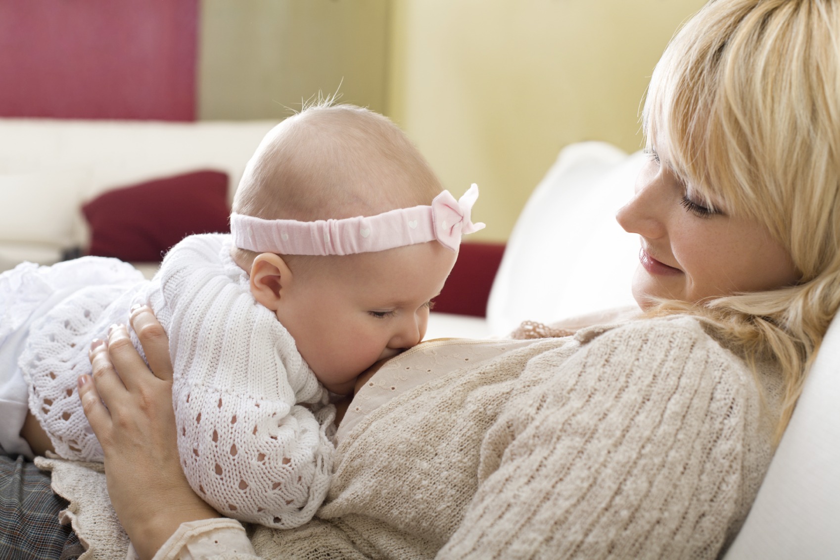 Mother breast feeding her baby girl at home