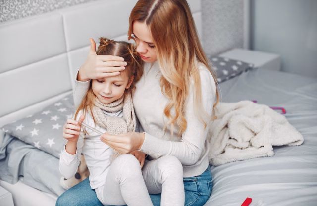 Mama skrbi za prehlajeno deklico v spalnici